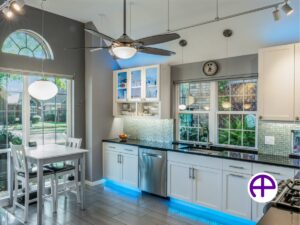 Designer kitchen showcasing black quartz countertops, white cabinets, and led lighting