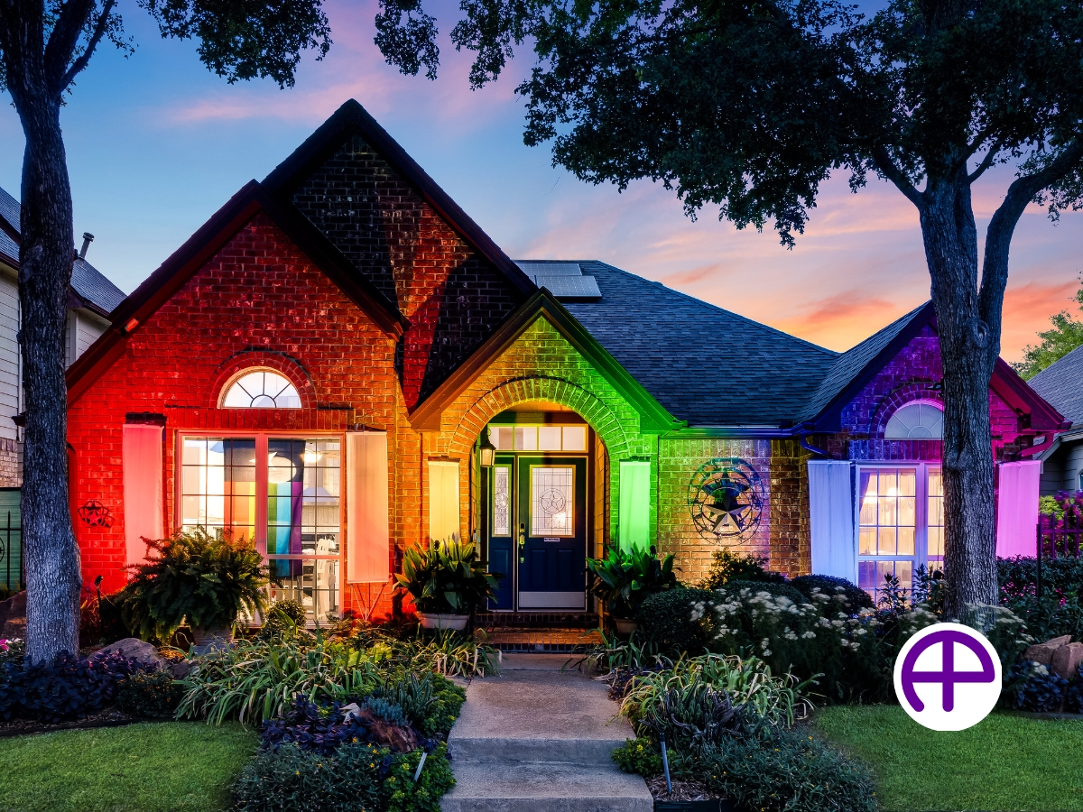 Twilight photo of single-story pride home with landscaping lights creating a large rainbow, featuring accutwilight™ and accusky replacement™ services