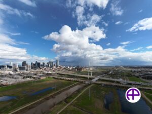 Aerial view of margaret hunt hill bridge with dallas skyline in the background captured by accudrones™, accuaerialphotos™, and accuaerialskyline™.