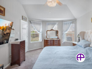 Elegant primary bedroom with three windows and high ceilings