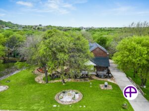 Aerial photo of a two-story home with lush lawn and trees