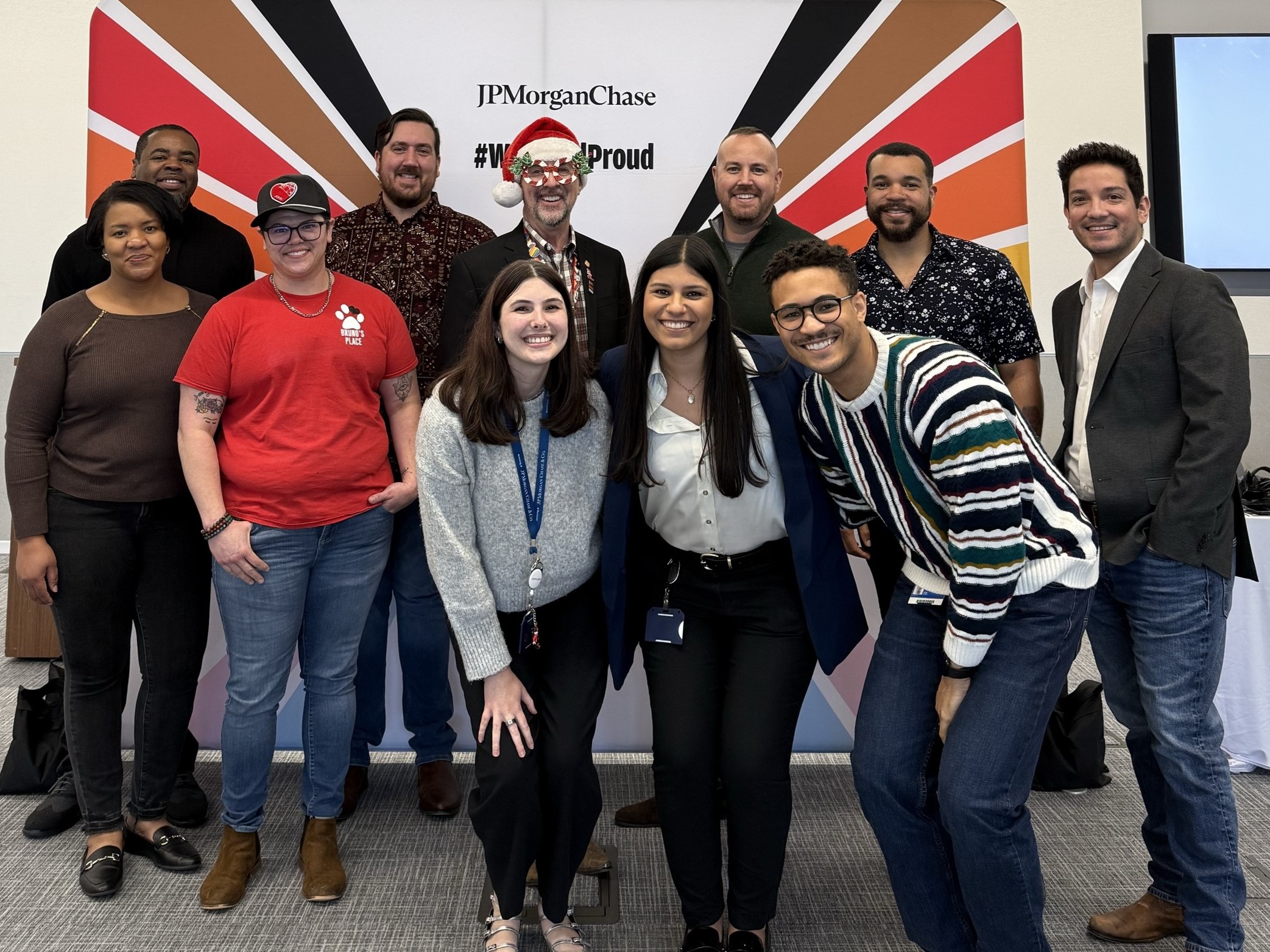 Group photo of participants at the jpmorgan chase pride showcase in plano in front of the #westandproud backdrop, organized by the chase lgbtq+ employee resource group.