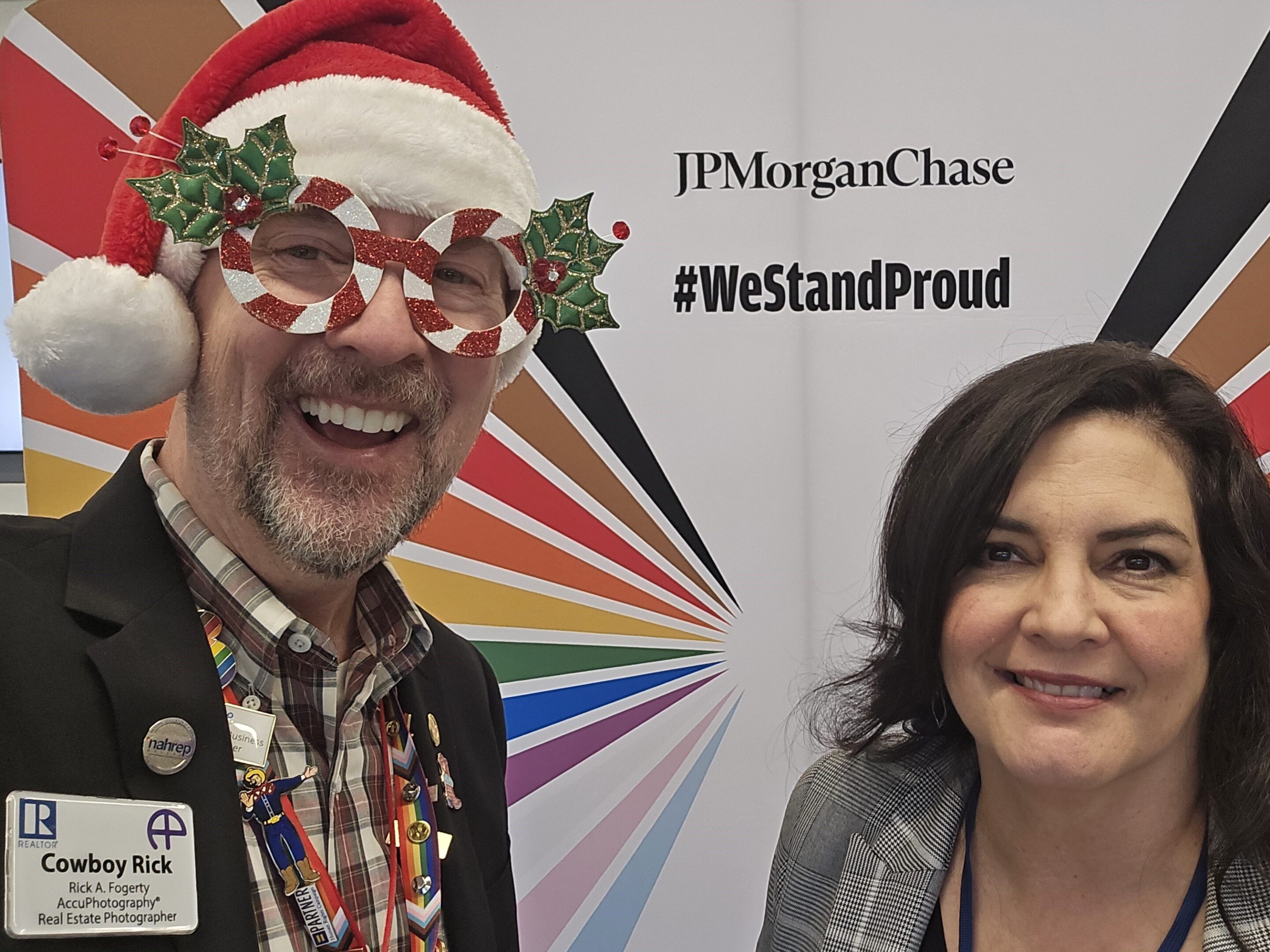 Rick a. Fogerty and sylvia andrade in front of the jpmorgan chase #westandproud backdrop at the chase pride showcase in plano.