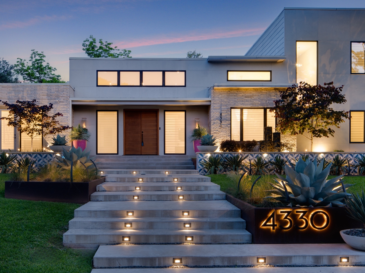 Accutwilightphotography enhanced image of dallas luxury home featuring illuminated house numbers, dramatic twilight sky, and warm interior lighting.